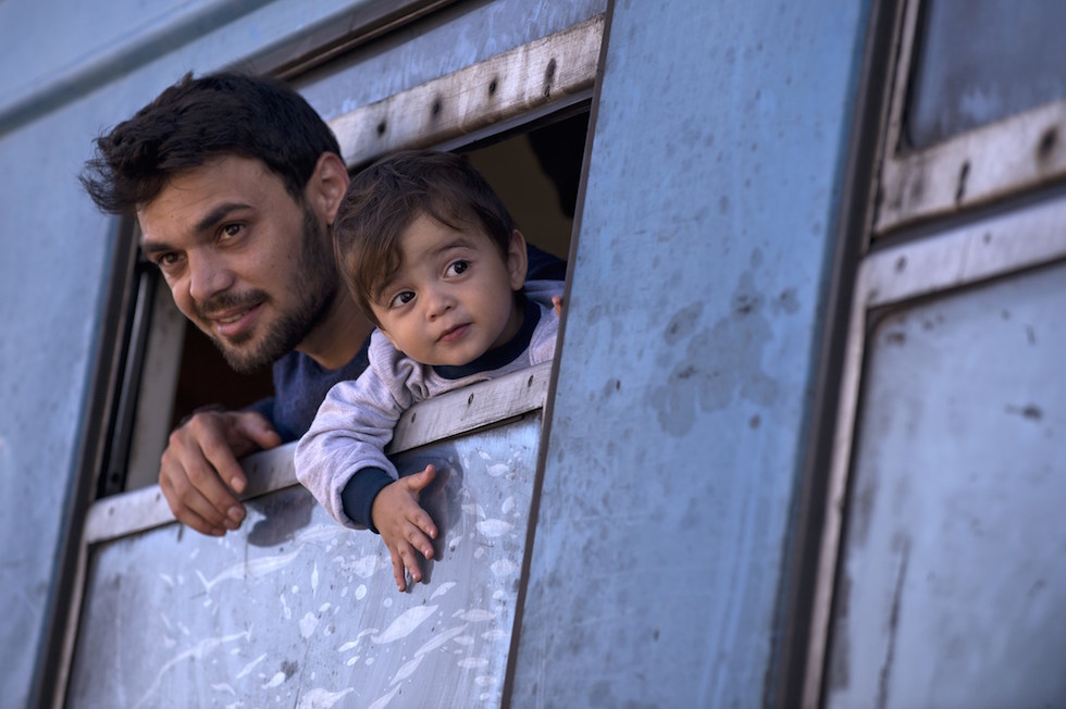 Un migrante e suo figlio su un treno diretto in Serbia, nella città Macedone di Gevgelija, 21 settembre 2015. (NIKOLAY DOYCHINOV/AFP/Getty Images)